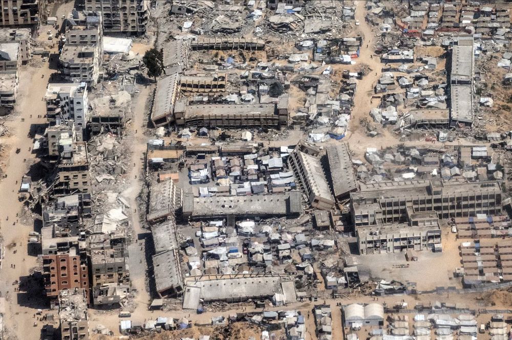 Several wrecked Gaza schools, shown from the air, pulverised by Israel's forces: windows all gaping, bombed out and covered in ash and dust. Some people are trying to live in makeshift camps amid the destruction, in former quadrangles and bomb sites. 