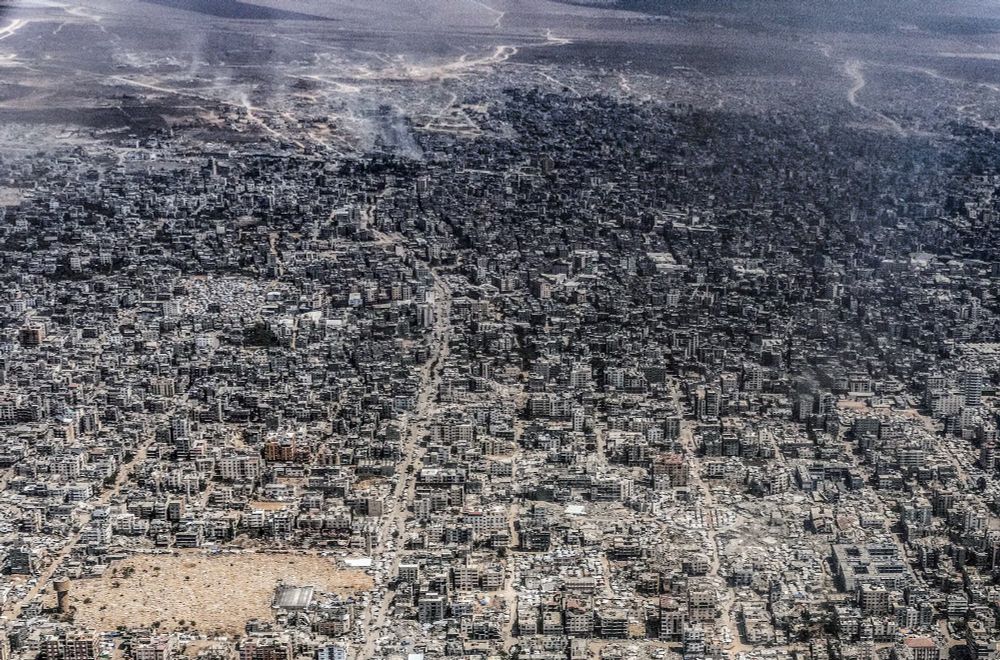 Aerial shot of Gaza City, burned and bombed into burned and shattered, unliveable wreckage as far as can be seen.