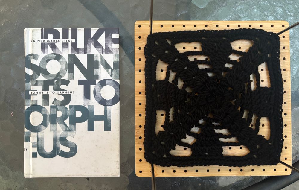 On the left, ‘sonnets to Orpheus’ by Rainer Maria Rilke, which has black type on a white cover. On the right, a black crochet square with a heart pattern 