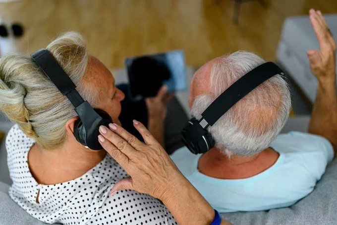 photo of an older woman and man listening to music