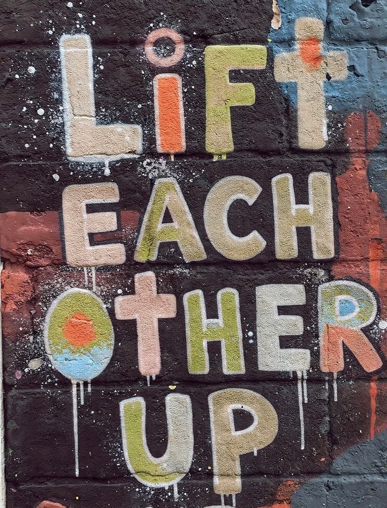 graffiti with the words "let's lift each other up"