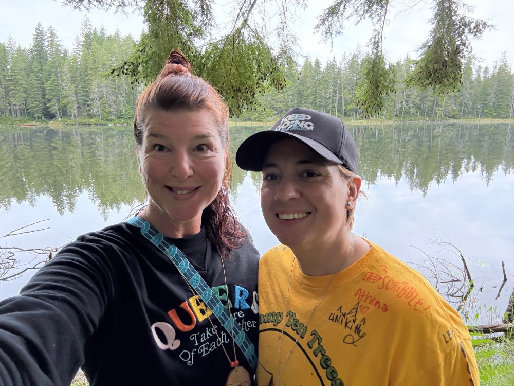 My wife and I smiling for the photo with the lake and trees in the background.