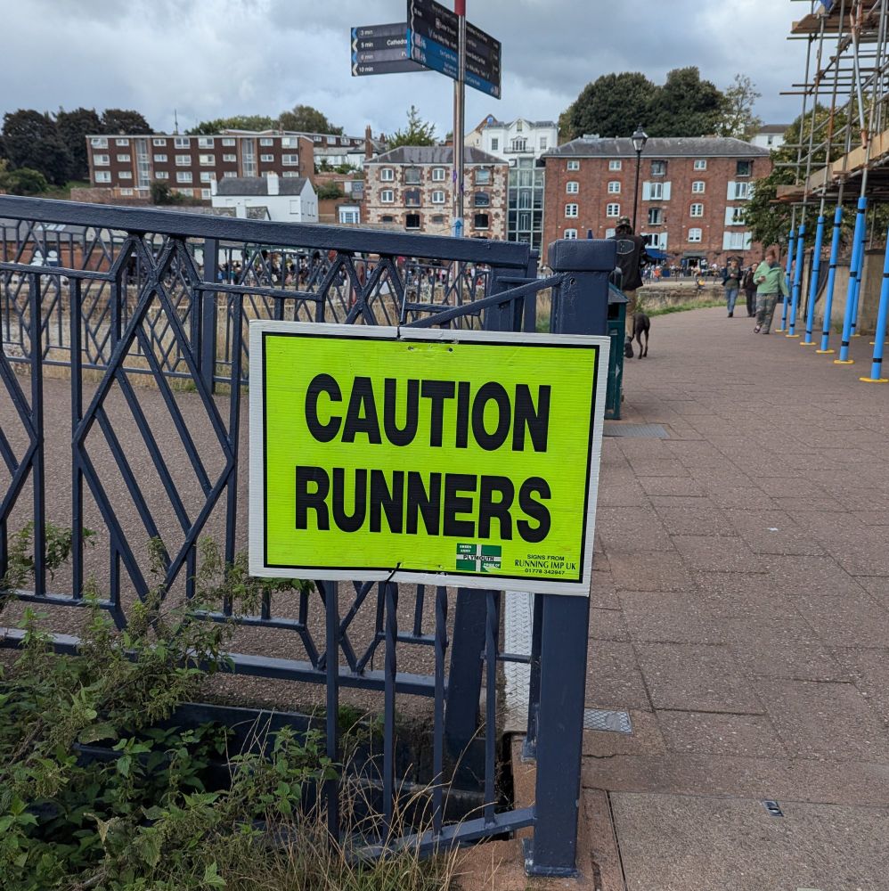 A sign that says 'caution runners', probably left over from a running event. 