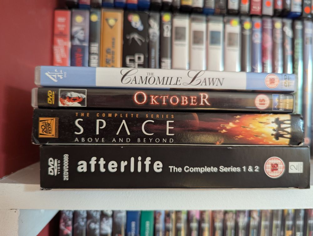 The spines of four DVDs and box sets, stacked together: The Camomile Lawn, Oktober, Space Above and Beyond, and Afterlife series 1 and 2.