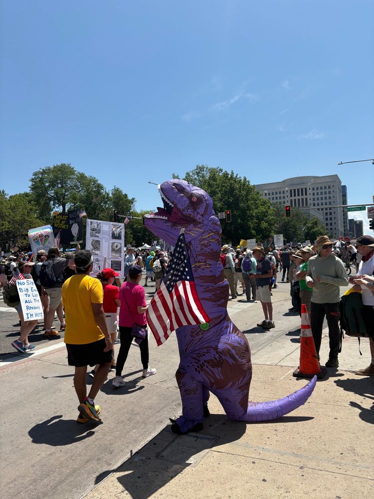 A purple dinosaur holds a US flag
