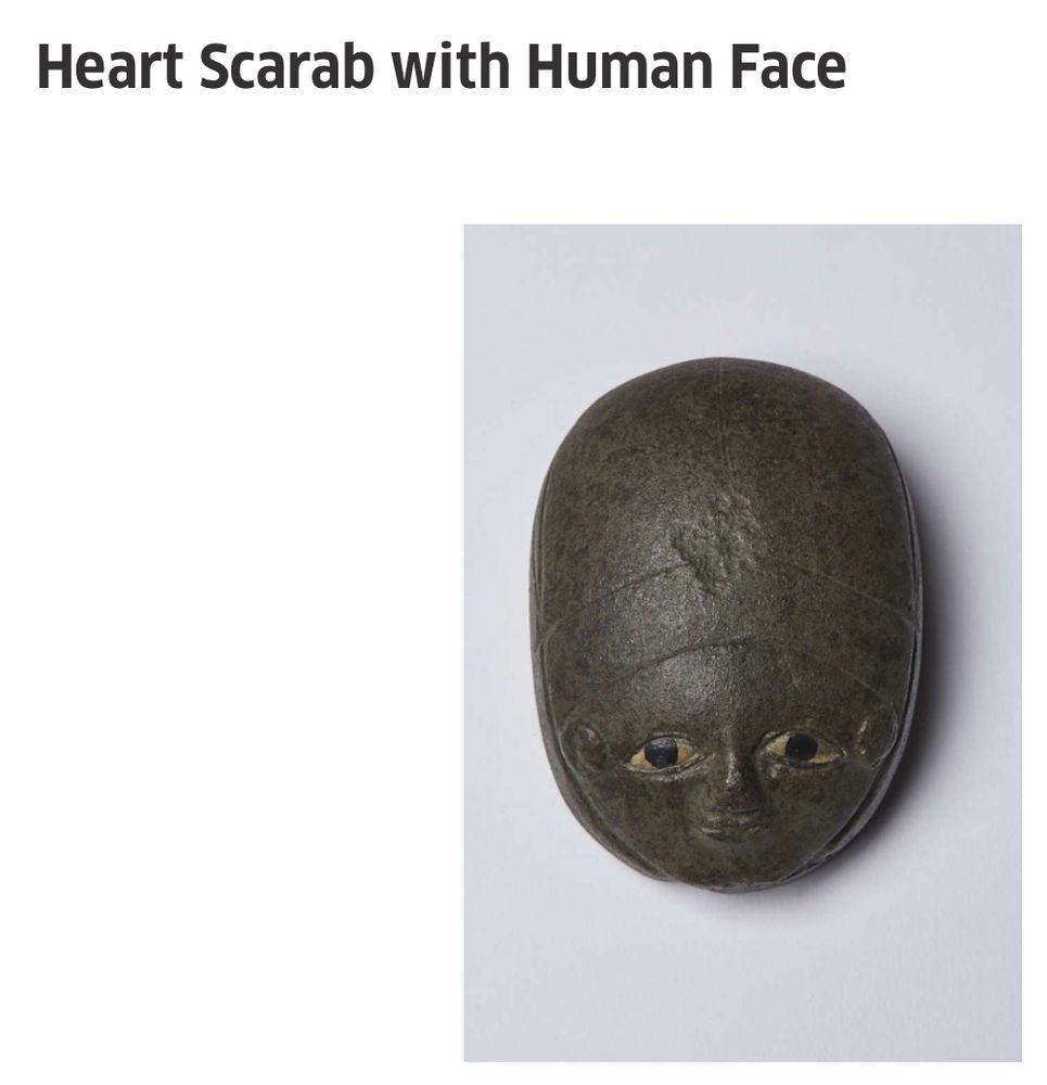 Screenshot of a small sculpture labelled 'Heart scarab with human face.' The sculpture is a scarab beetle with a friendly human face. Like Thomas the tank engine but with a beetle.