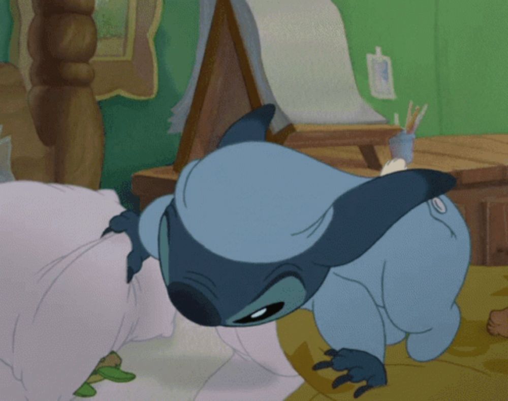 a cartoon character is laying on a bed with a pillow