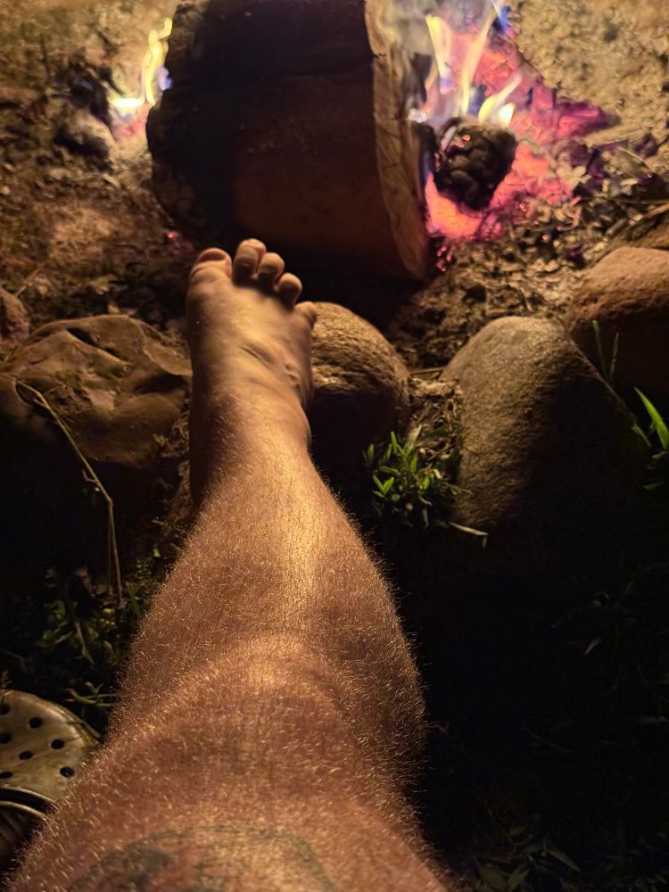 Foot on a rock at a fire