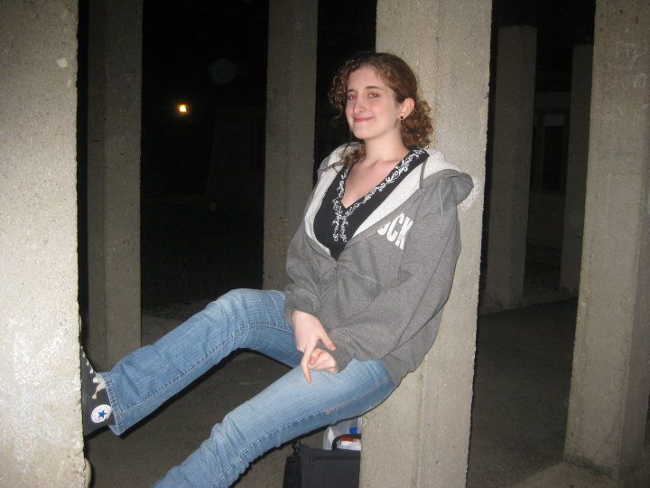 A person balancing between two concrete posts and smiling 