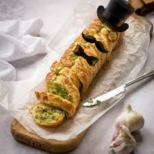 A loaf of garlic bread with a top hat, monocle, moustache, and bow tie 