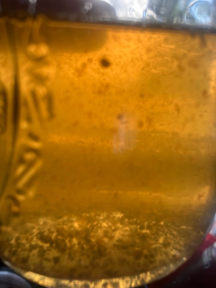 Mason jar of cardamom syrup with ground spices partially emulsified 