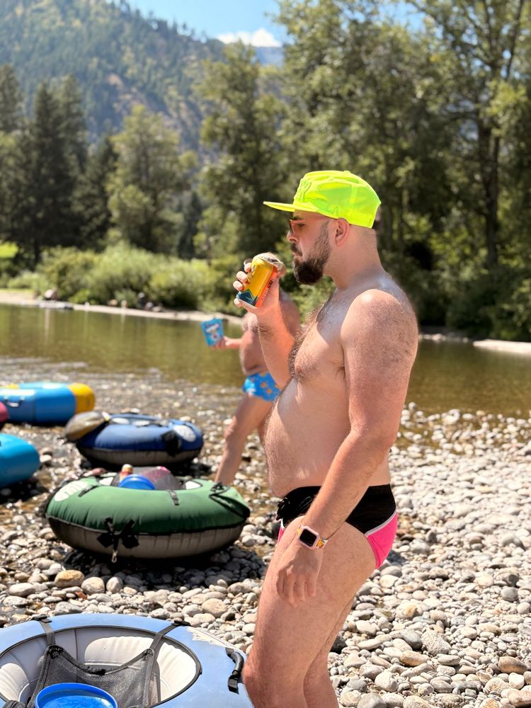 ItsCodes in a speedo and a hat about to drink from a can, he’s riverside.