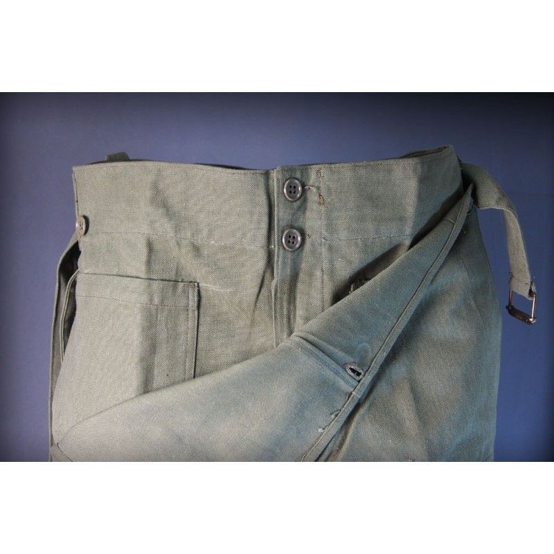 Close-up of the pants' waistband, with its fold-over design, side button, and hidden inner front pocket.