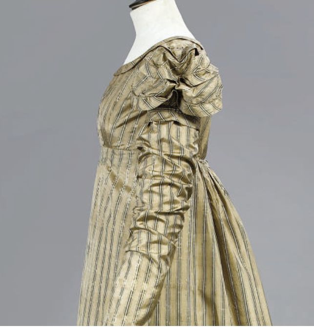Photo of a similar dress, but made with striped material which reveals the construction a little more. The dress has a short sleeve that is puffed and gathered across the center, and is hemmed at its bottom, then another longer sleeve is sewn on. Sold by Christie's, with a listing here: https://www.christies.com/en/lot/lot-5120781