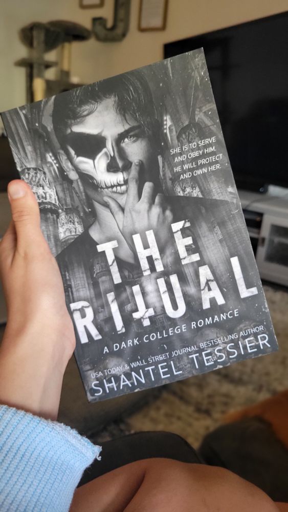 Cover photo of "The Ritual" by Shantel Tessier. All grey with white font, a man with half his face painted like a skeleton.