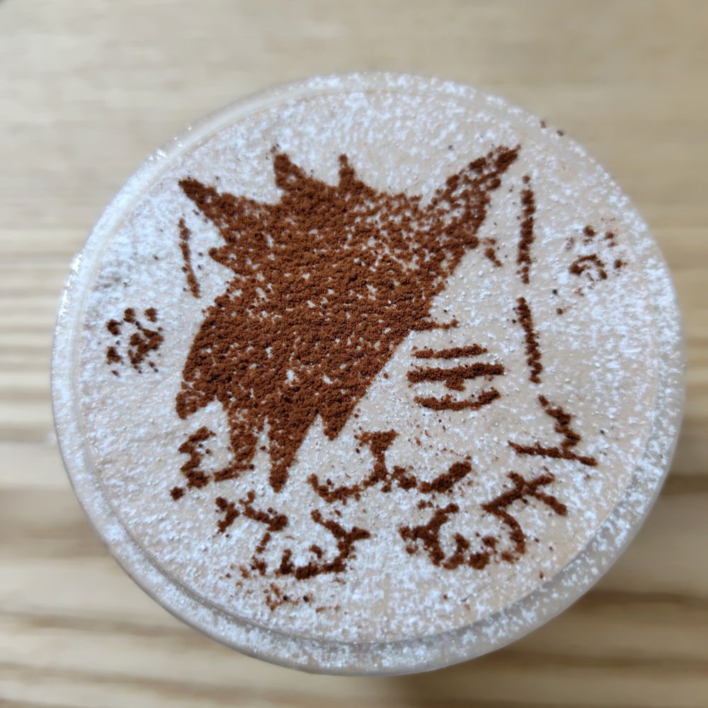 カッププリンの写真。ココアパウダーでクロオネコが描かれている。