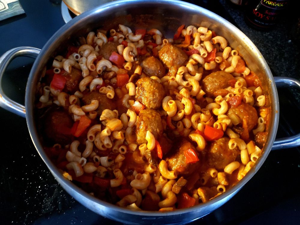 A warm pot of elbow macaroni just sitting on the stove ready to be hoovered up.
