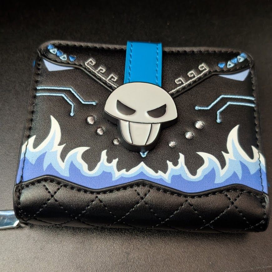 A photograph of the front of a Disney Twisted Wonderland themed wallet, decorated with blue flames and a skull clasp, to represent the Hades themed dormitory of Ignihyde.