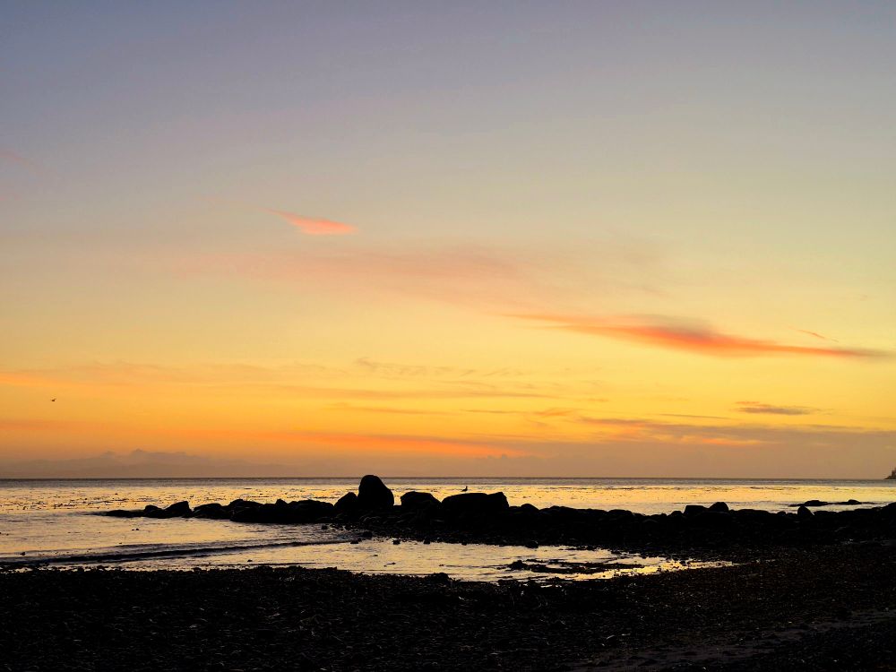 Sunset skies, the stage is set, stunning shoreline silhouettes. Seabirds sing songs in the shallows, serenading from the silent shadows. Sea and salt, stones and sand, in sculpted serenity, surrounded i stand.