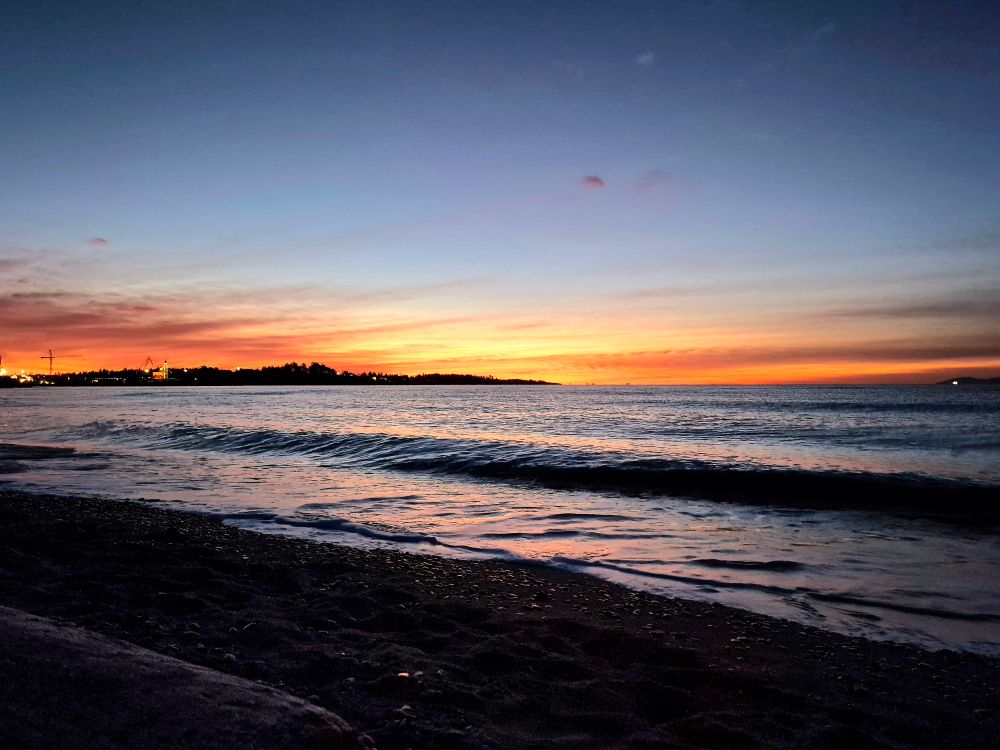 Moments before sunrise over the Pacific Ocean, the horizon is glowing with anticipation of the coming sun. It radiates with colors of red, orange and yellow. 