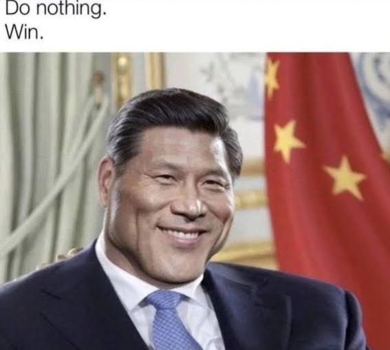 A imagem mostra um homem de terno e gravata sorrindo, sentado em um ambiente formal, com uma bandeira vermelha com estrelas amarelas ao fundo, que lembra a bandeira da China. Na parte superior da imagem há um texto escrito em inglês: “Do nothing. Win.” (“Não faça nada. Vença.”). O contraste entre a expressão confiante e o texto sugere um tom de humor ou ironia, como se a vitória fosse alcançada sem esforço algum. A composição remete a um estilo de meme, no qual a frase curta e a imagem transmitem juntos uma mensagem sarcástica ou engraçada