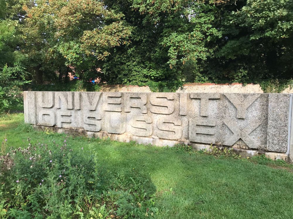 Concrete campus sign that says University of Sussex