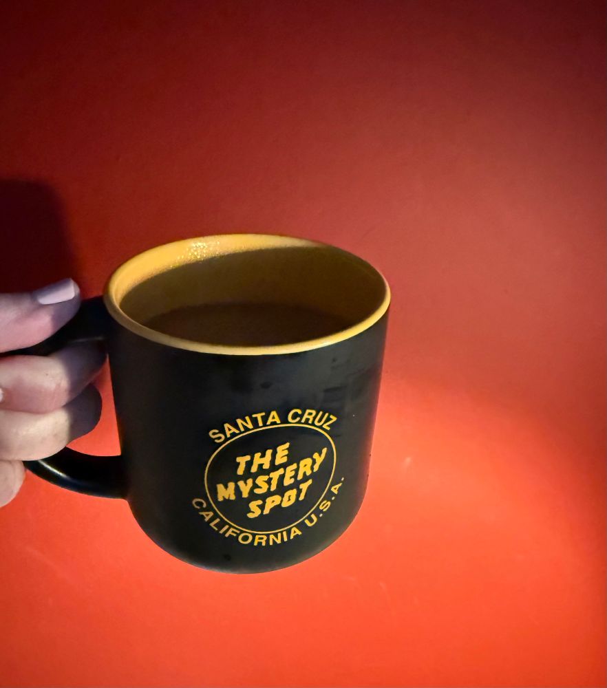 Black coffee mug against a red wall