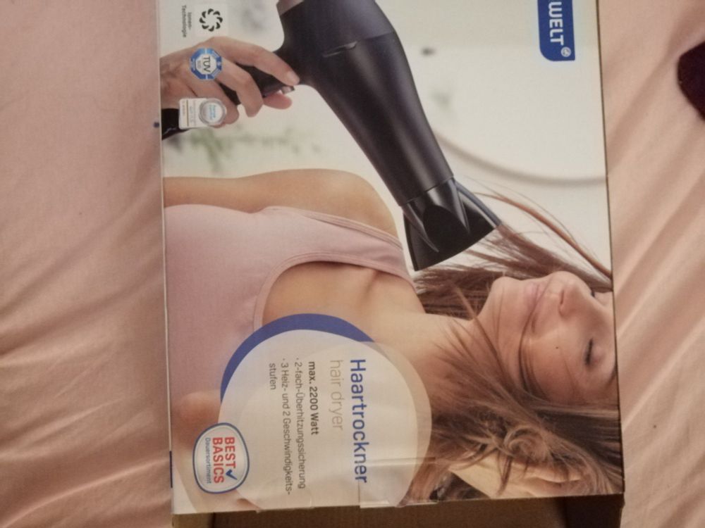 Föhn Verpackung mit junger Frau, deren Haare dem Föhn entgegen wehen