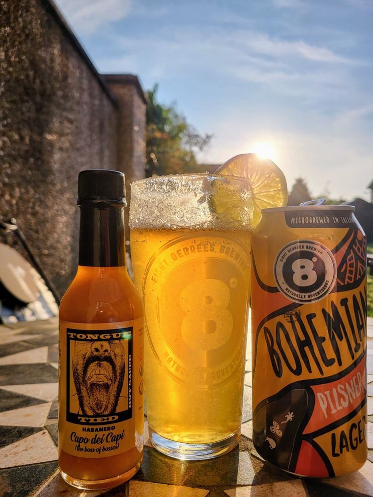 A Michelada with hot sauce and a beer 