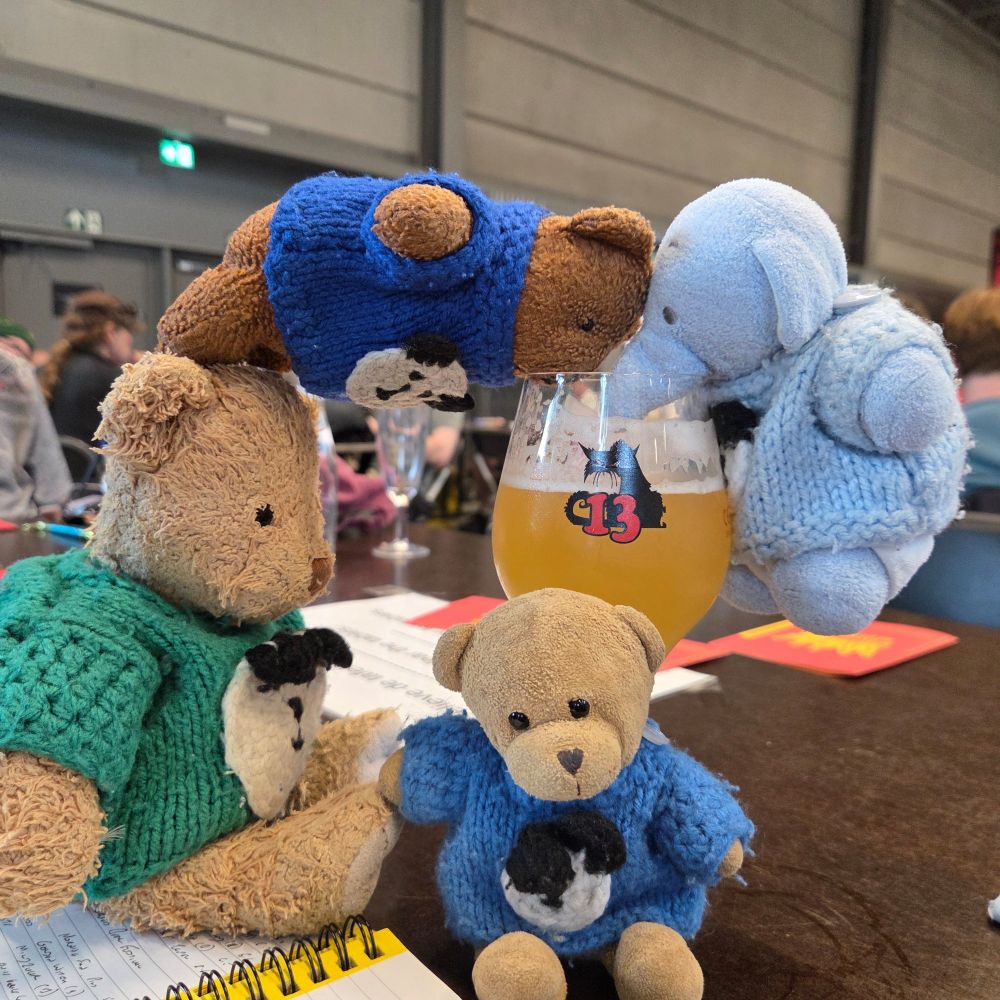 Three small bears and a small elephant at a beer festival. 
