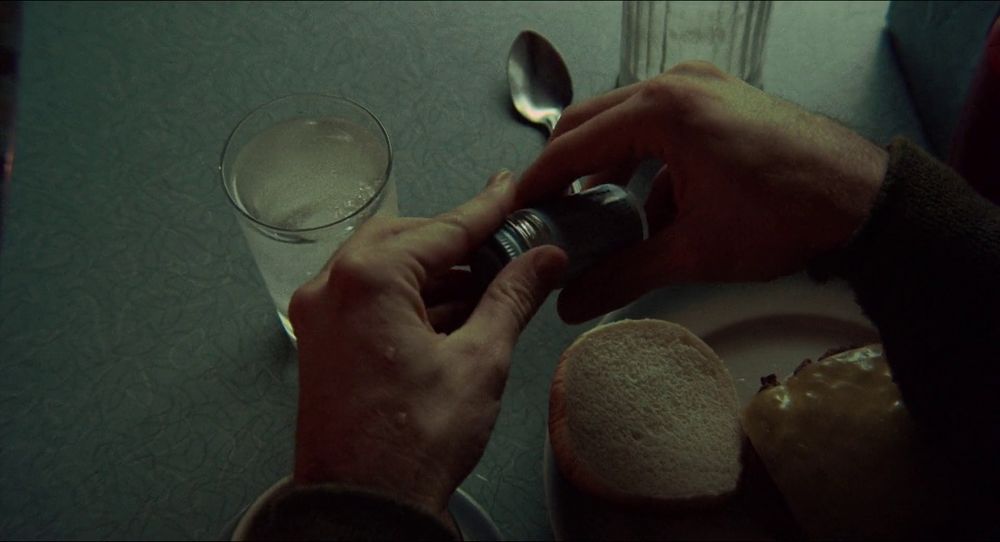 TAXI DRIVER: Travis' hands opening a pill bottle over a diner table with a sad cheeseburger