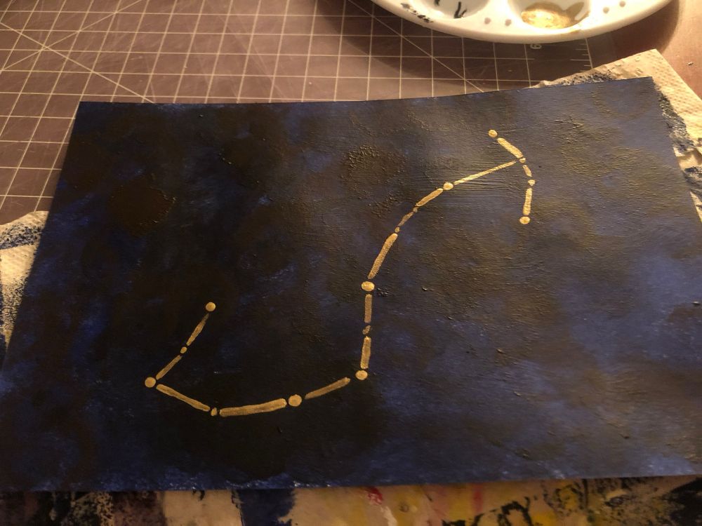 An acrylic paining of a gold constellation on a blue-black background 