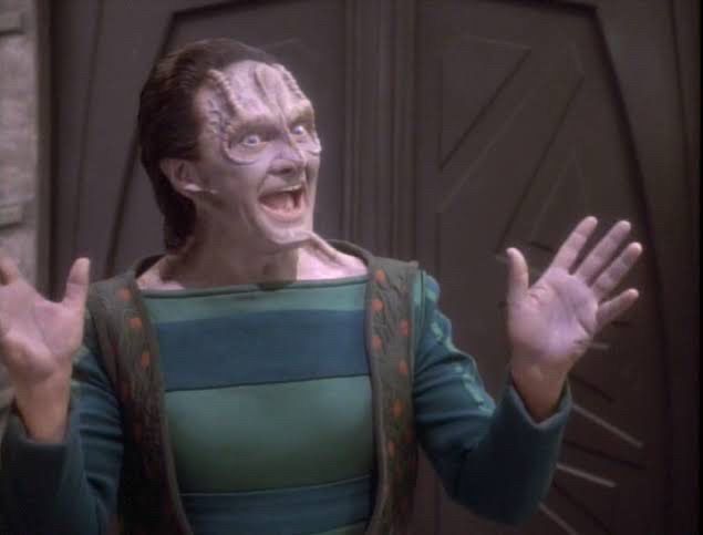 It’s Elim Garak, the Cardassian tailor of DeepSpace9! In a green and blue striped shirt, and jazz hands. 