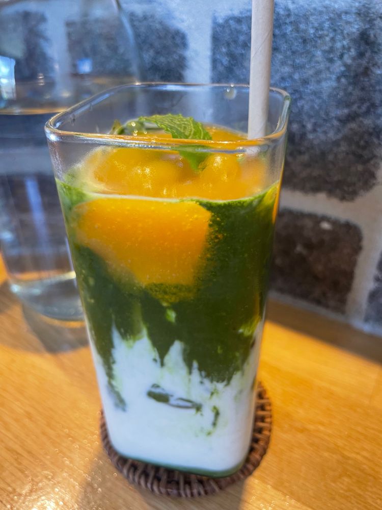 Tall icy glass with bright orange mango puree, grassy green matcha syrup and creamy milk - Mountain River’s Mango Matcha. 