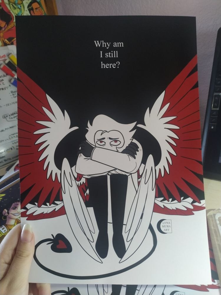 A big print of Lucifer Morningstar, sitting in the floor with his wings open and looking up. Black background with a text in white: "Why am I still here?"