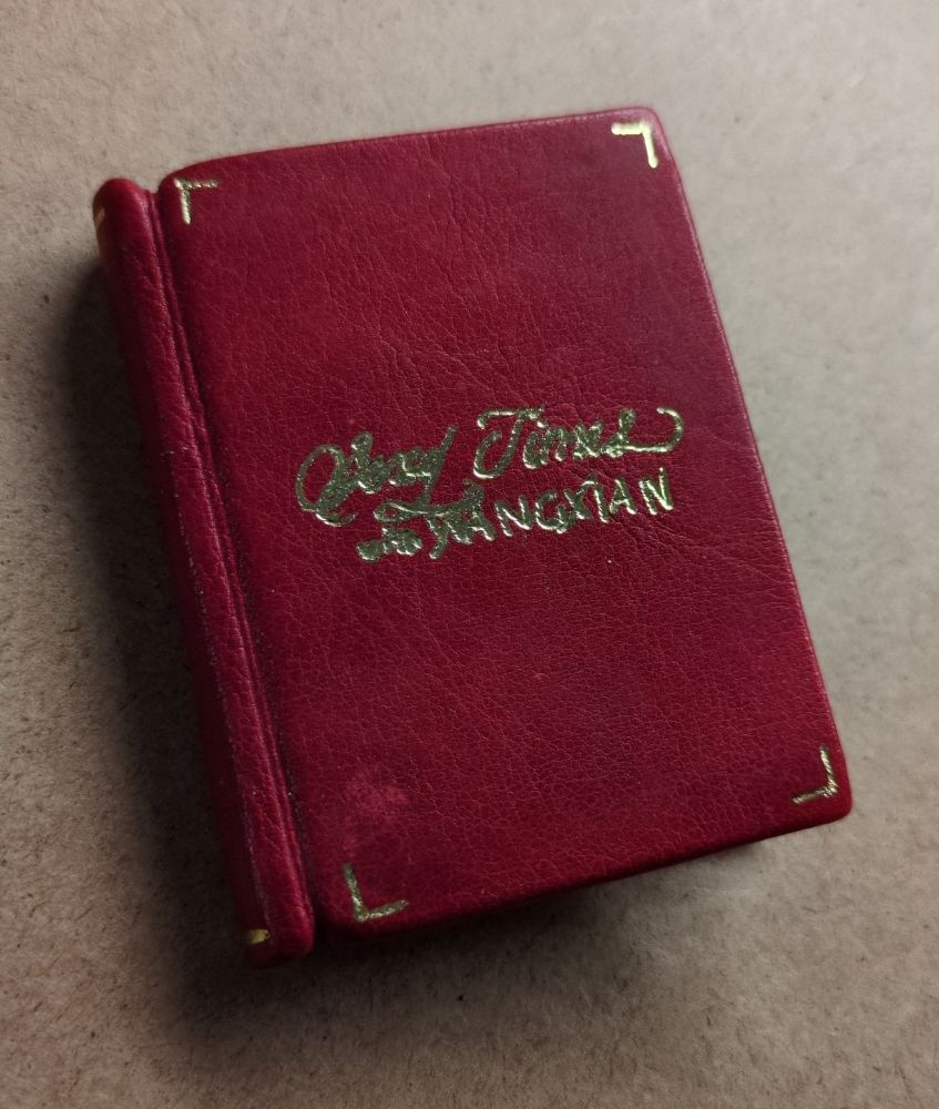 A small book bound in red leather, with the title "Sexy Times with Wangxian" in (somewhat messy and a bit hard to read) gold foiled letters in the center