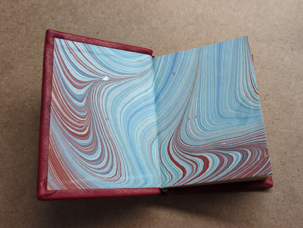 The endpapers are marbled paper with a red and blue abstract swirl