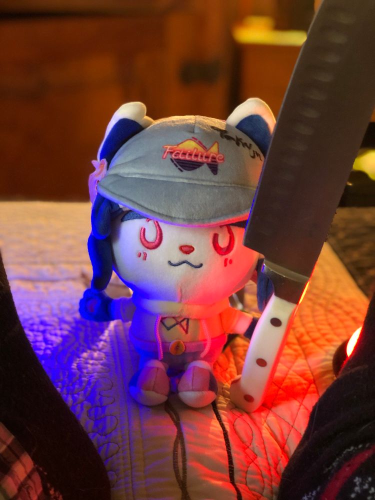 A YonKaGor Tetra plushie sits at the foot of a bed... menacingly.