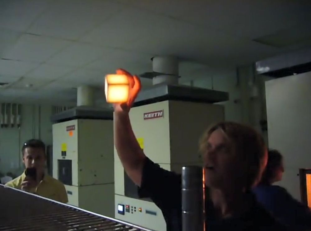 A man holding a red-hot (1200 °C) block of Li-900 his hands