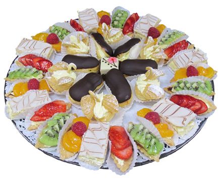 Platter with mini fruit tarts, eclairs, napoleons, and cream puffs that look like little swans 