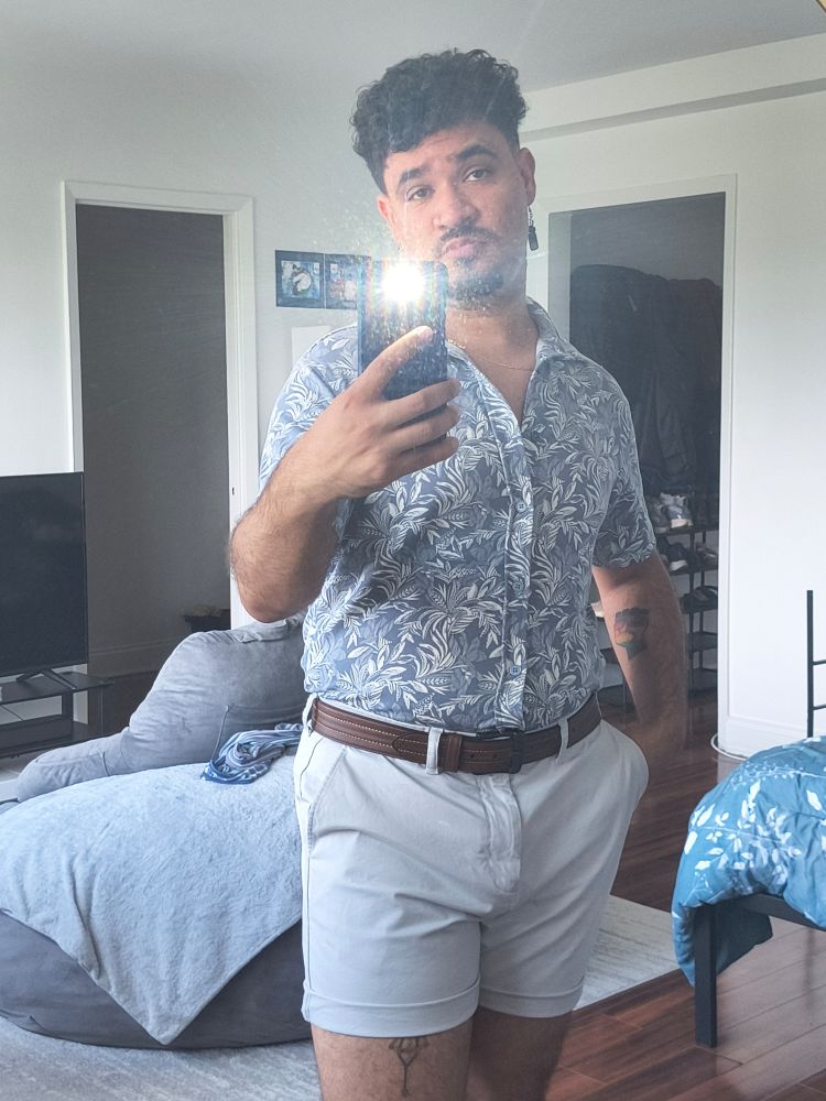 Mixed gay wears the complete gay ass outfit with gray rolled up shorts, soft blue button down and dangly earrings
