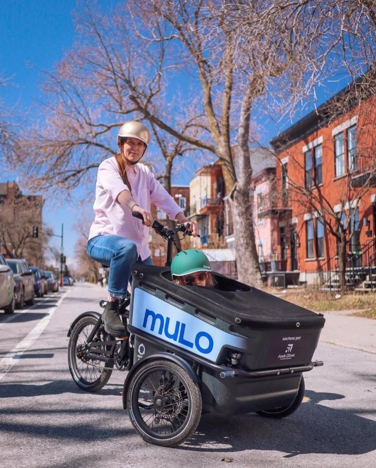 Une mère se déplace en bakfiets de Mulo dans les rues de Montréal avec sa fille comme passagère. Photo : Mulo (Instagram).
