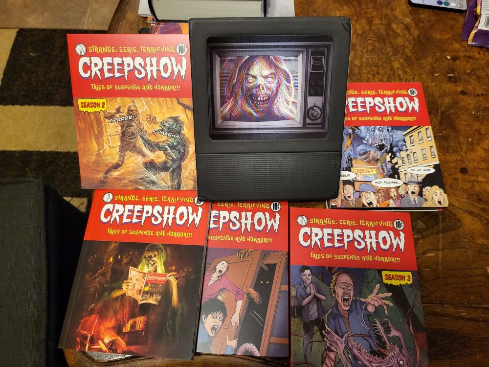 The four-season box set for the Creepshow TV series, spread out on a table and looking like a set of horror comic books.