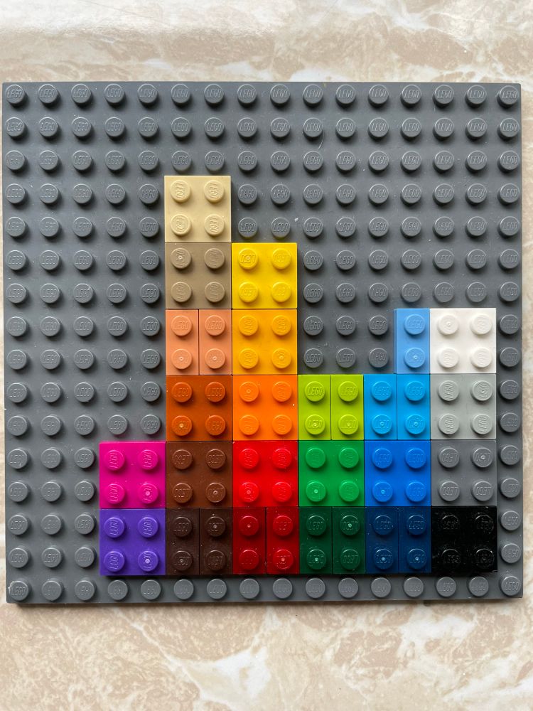 A LEGO plate with a spectrum of the various LEGO colors on it.