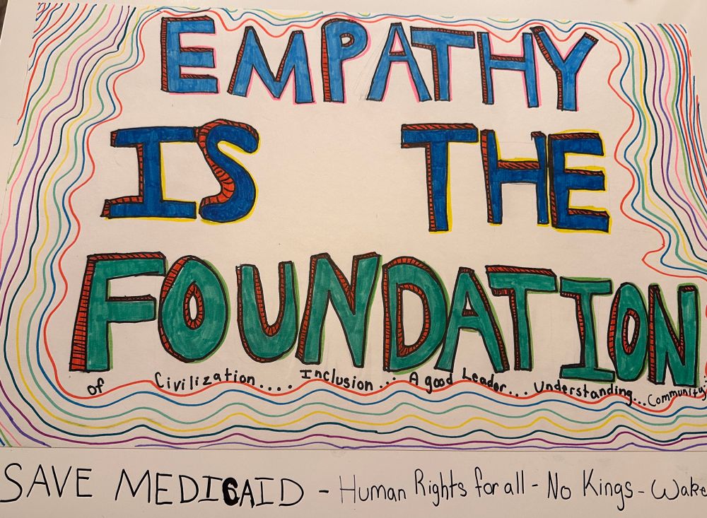 Written large “EMPATHY IS THE FOUNDATION” 

written small “of civilization….inclusion….a good leader….understanding…Community”

Underneath “Save Medicaid - human rights for all - No Kings - Wake Up”