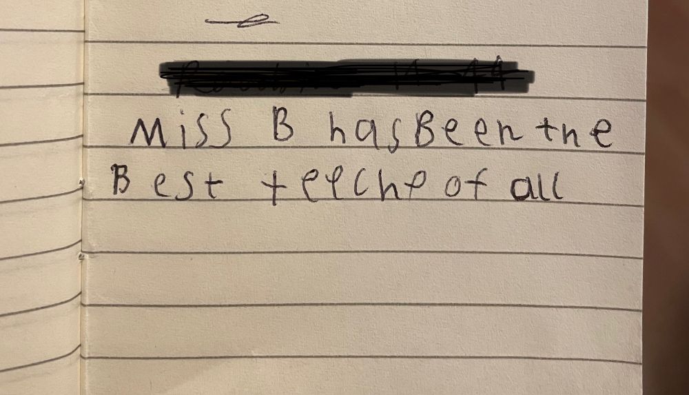 Photo of a lined notebook page with child’s writing saying “Miss B has been the best teacher of all” and teacher isn’t spelled correctly 