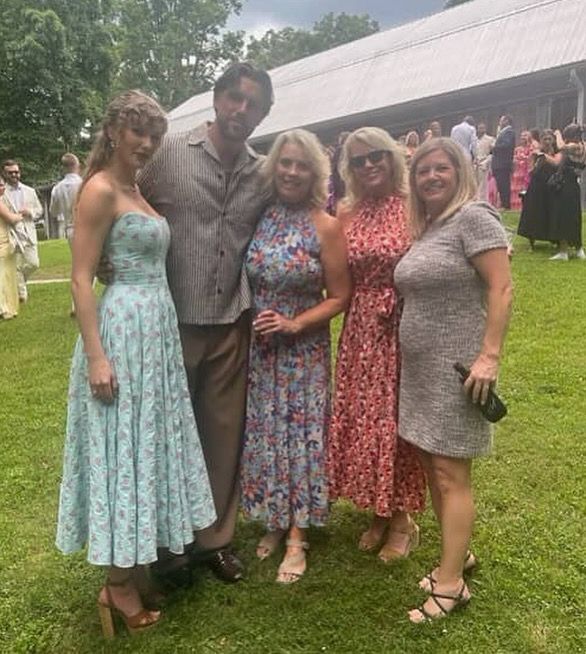 Taylor Swift and Travis Kelce posing for photos with other wedding guests 