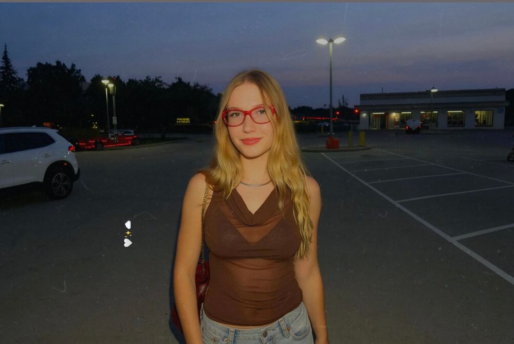 Beautiful blonde hair girl wearing red glasses and posing for a photo 
