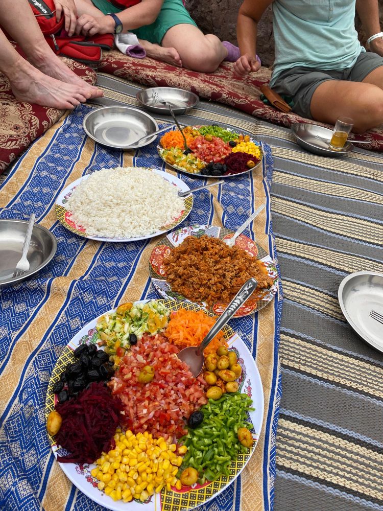 A picnic feast of Moroccan salads and couscous laid out on a blanket in the Atlas Mountains 