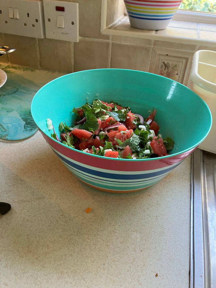 A bowl of watermelon, feta cheese, black olive, parsley, mint and red onion salad in a lime and olive oil dressing. Scrumptious enough to inhale. 